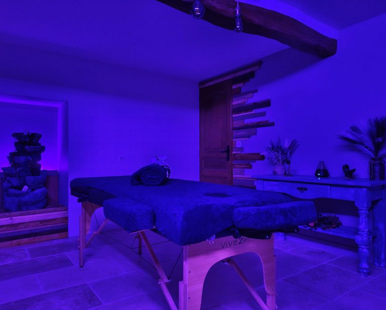 Massage & relaxation Salle de massage avec table, fontaine et galets, diffuseur d'huile, ambiance lumineuse zen et accessoires relaxants.